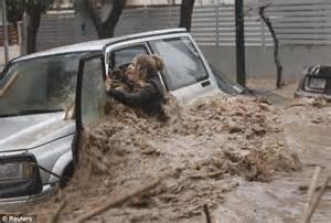 Woman trapped, clinging to car